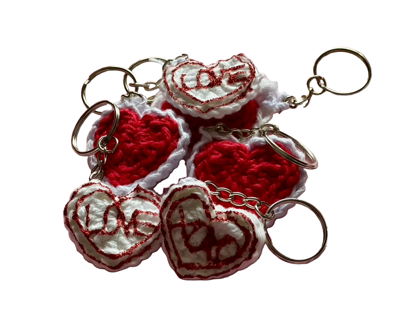 Crocheted red and white hearts attached to keychain ring, red lettering on white hearts reads "love" and "xoxo"
