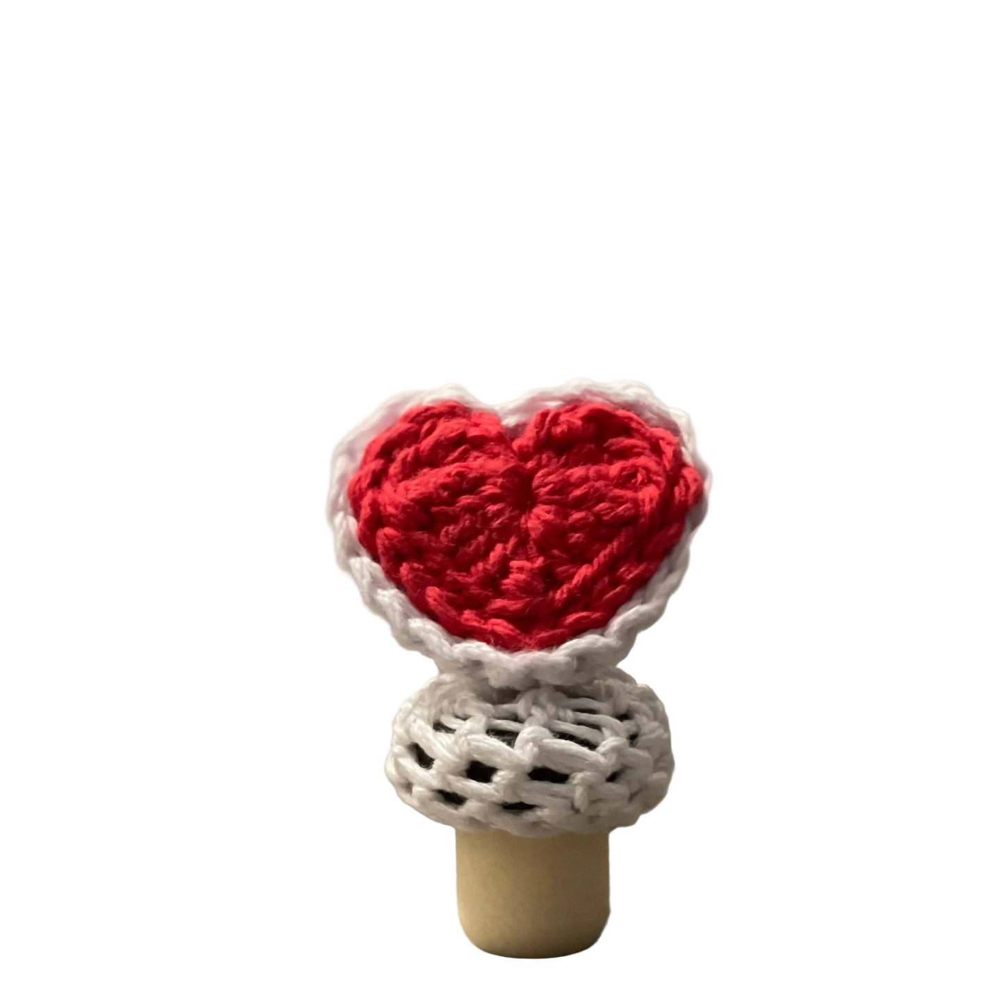 A red crocheted heart with white lace on a bottle stopper