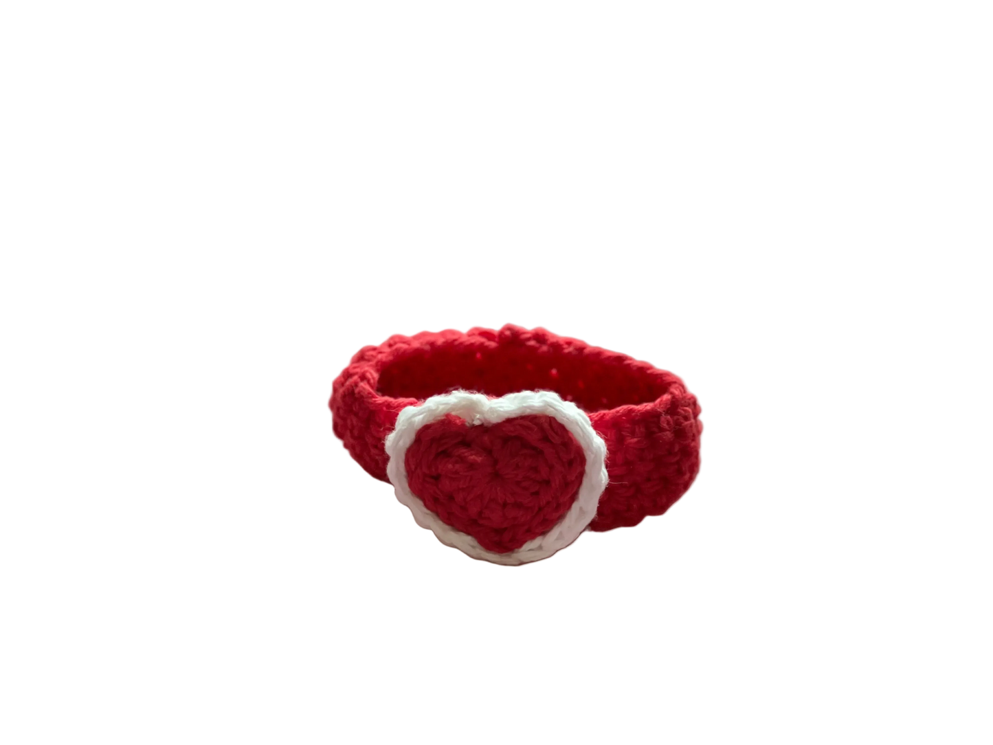 A crocheted red heart with white lace attached to a red crocheted wristband