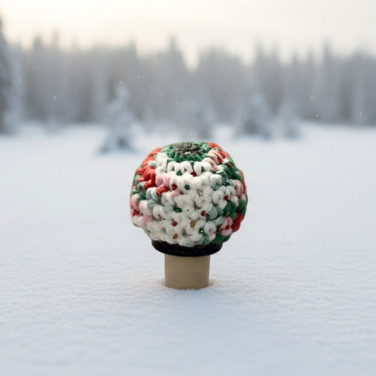 A small crocheted glittery Christmas ornament on a bottle stopper