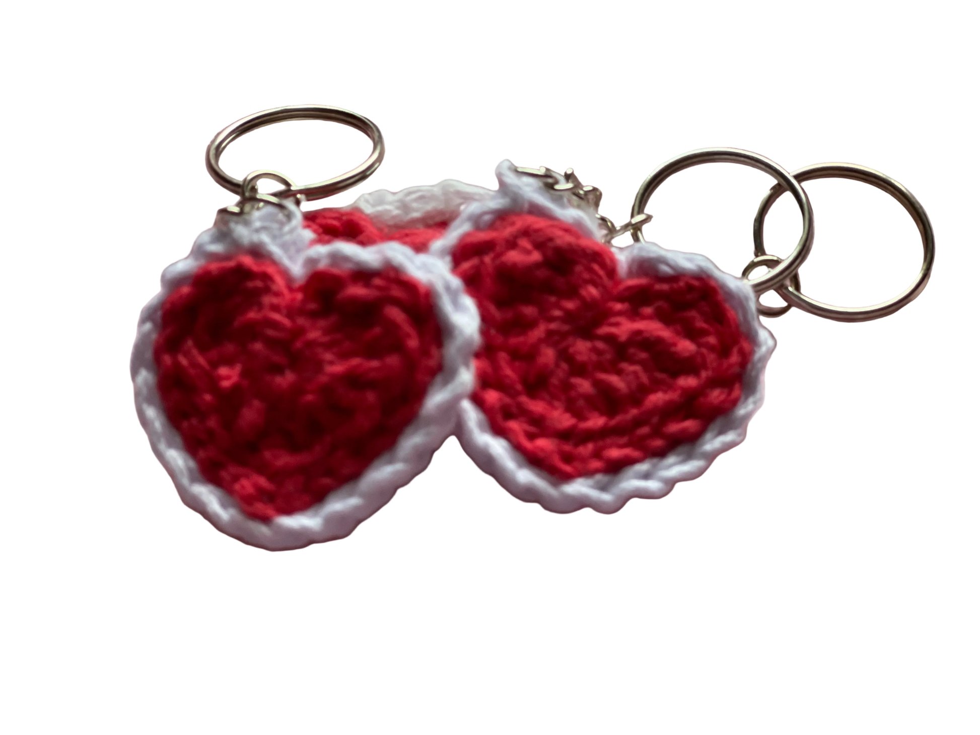 Crocheted red hearts with white lace attached to keychain rings