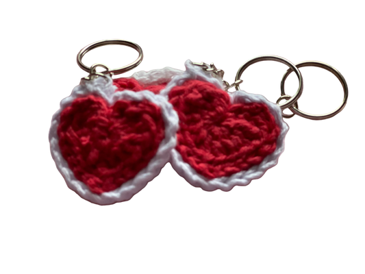 Crocheted red hearts with white lace attached to keychain rings