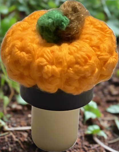 Crocheted pumpkin against a natural background.